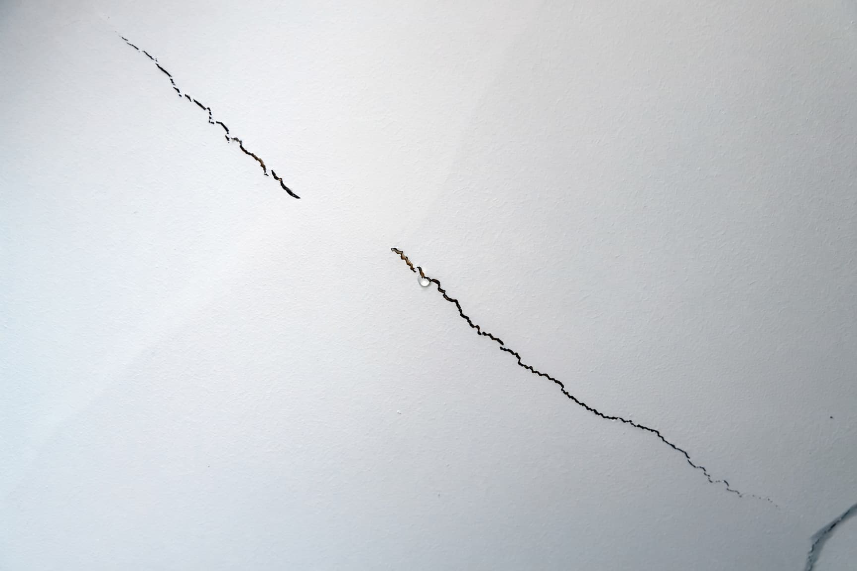Straight crack running along a drywall ceiling seam in a Raleigh home before re-taping